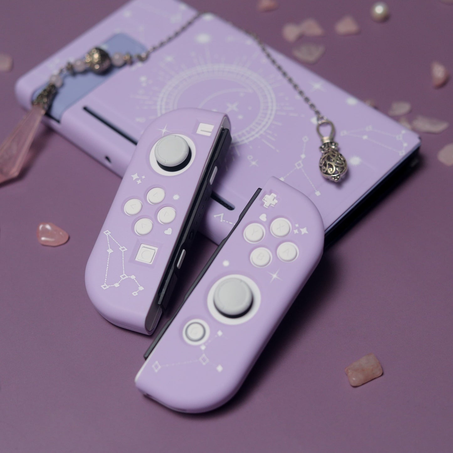 Lavender Nintendo Switch Cosmic Moon case and Joy-Con covers with white celestial star pattern, styled with rose quartz crystals