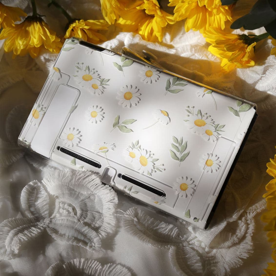 Clear Nintendo Switch Daisy Daydream snap-on console case with watercolour daisy and leaf pattern, styled with yellow flowers