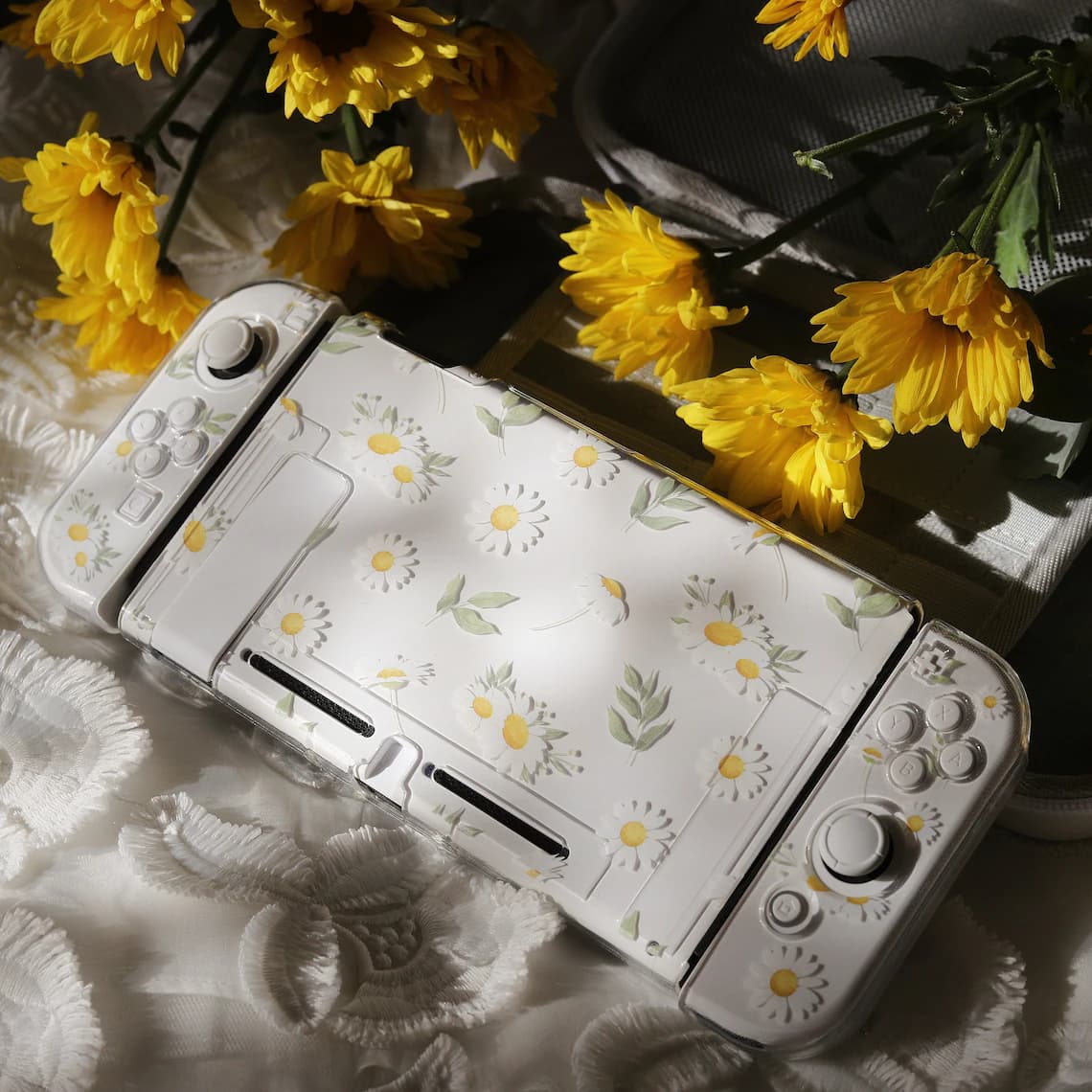 Angled view of assembled Nintendo Switch with clear Daisy Daydream floral case and Joy-Con covers on white lace fabric