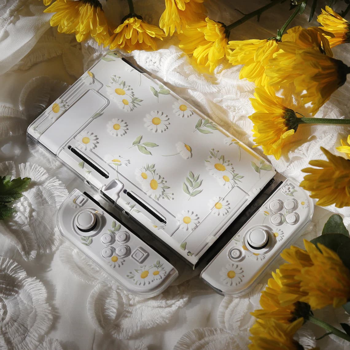 Overhead view of Nintendo Switch with clear Daisy Daydream case and Joy-Con covers assembled, surrounded by yellow flowers