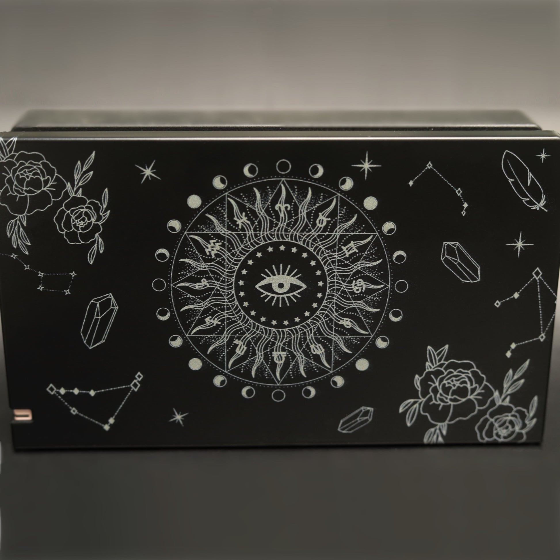 Black Nintendo Switch dock cover with white Solaris Noire celestial sun eye, moon phases, roses and crystal pattern