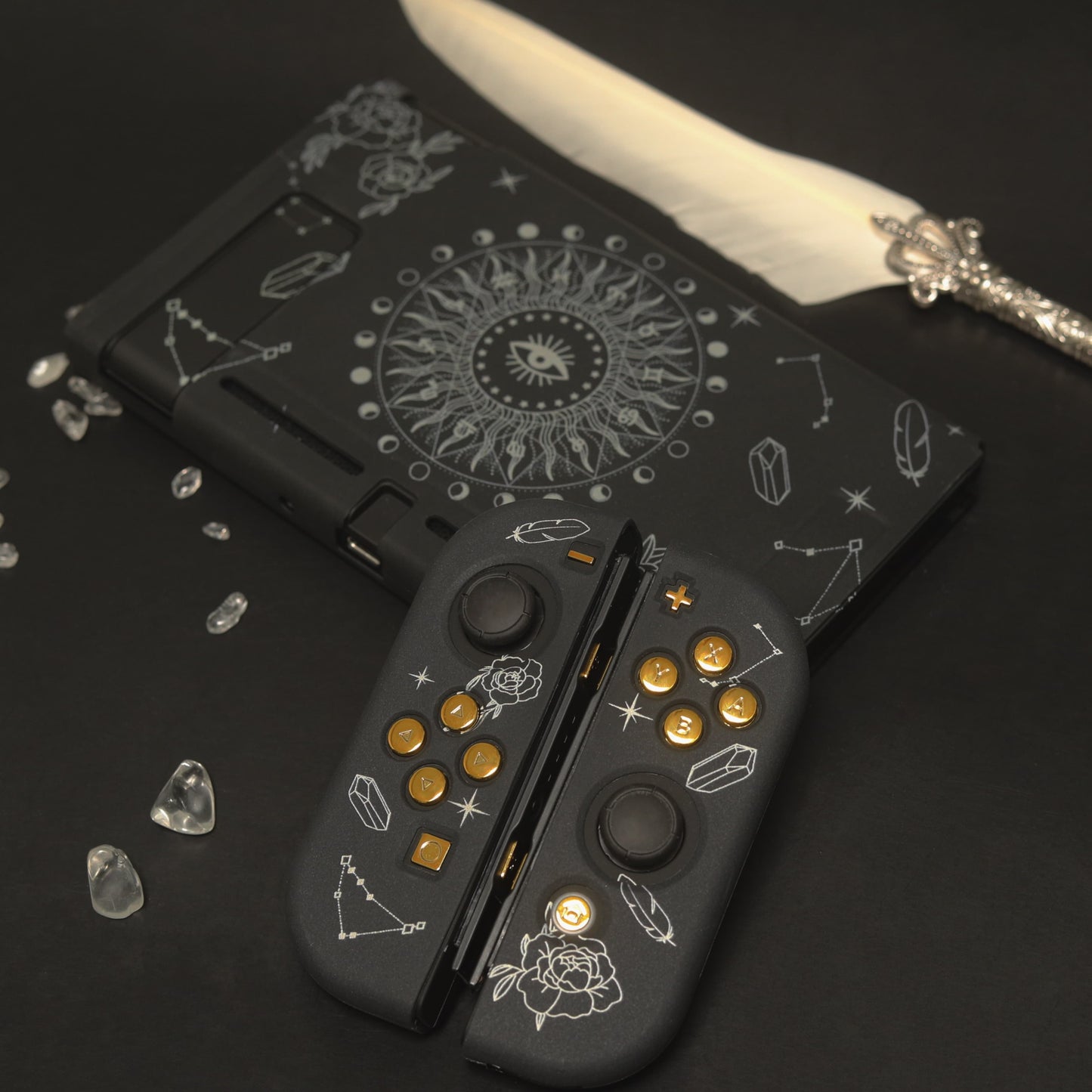 Close-up of black Nintendo Switch Solaris Noire Joy-Con covers with white rose and constellation pattern and gold button accents