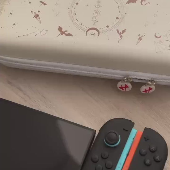Short video showing the Emberwing carry case with dragon and moon print, plus matching Joy-Cons on a wooden surface.
